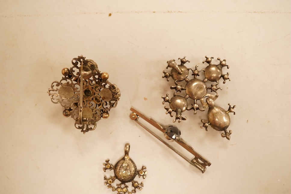 A late 19th/early 20th century Viennese pierced white metal, enamel and garnet cluster set brooch, 34mm, together with four other items of paste set jewellery.